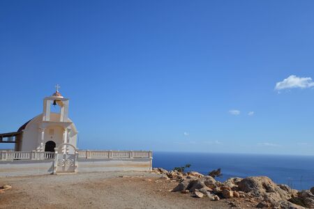 white chapel on rock near sea
