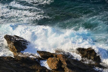 waves splash at stones on shore seaの写真素材