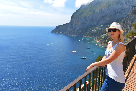 Woman in hat near fence in mountainsの写真素材