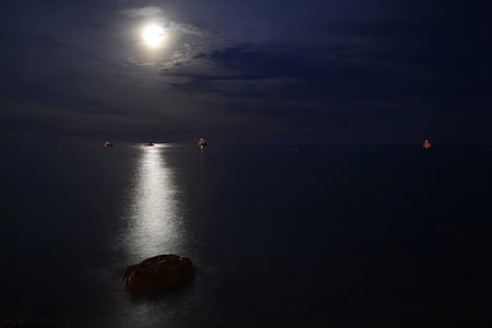 Moon over blue water. Night landscapeの写真素材