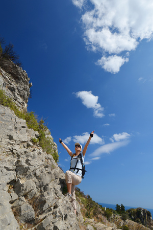woman climbs mountainside to topの写真素材