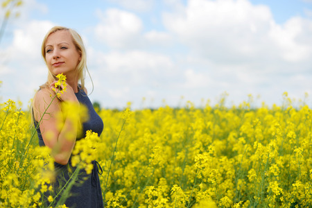 Charming woman at  field of canolaの写真素材