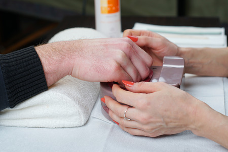 Beautician is doing  manicure to her costumerの写真素材