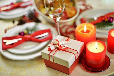 table setting  with candles. fork, knife and red napkin on dishの写真素材