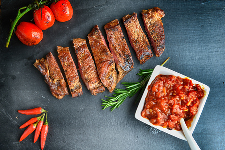 steak and vegetables on black plateの写真素材