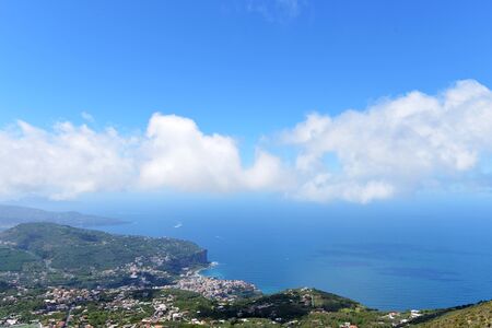 resort city in mountains and sky with cloudsの写真素材