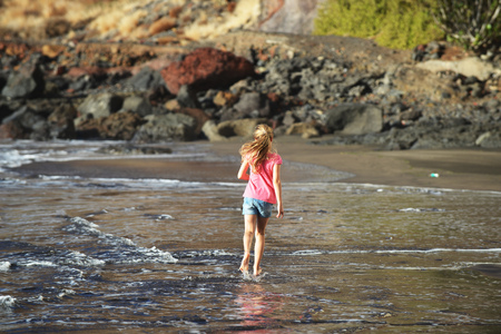 cute girl is playing on sandy beachの写真素材