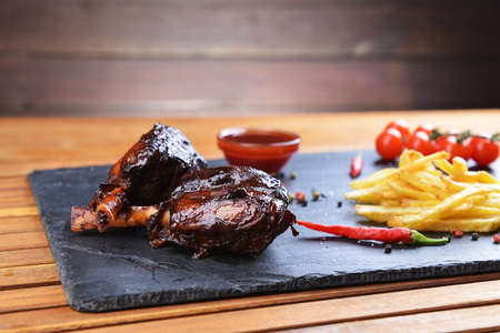 Fried potatoes and pork with bone on plateの写真素材
