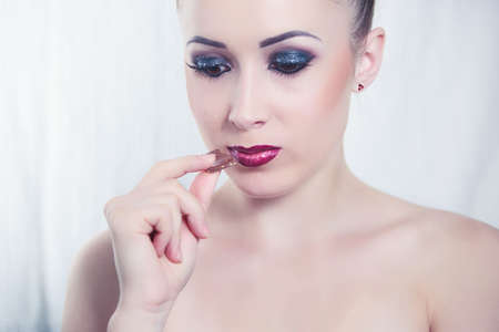 Fashion portret of attractive young woman eat a chocolateの写真素材