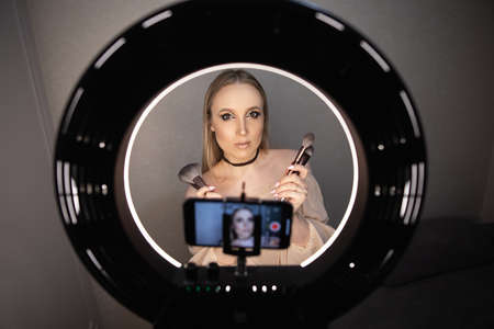Beauty blogger recording makeup tutorial video at homeの写真素材