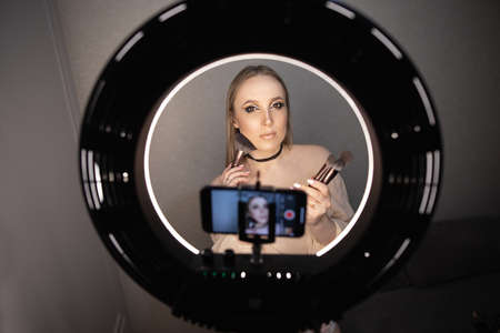 Beauty blogger recording makeup tutorial video at homeの写真素材