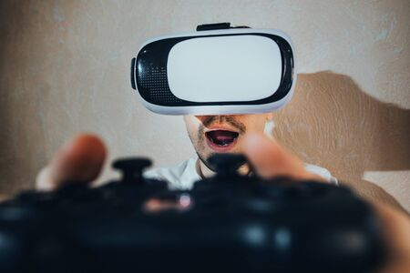 the emotions of a man playing with the joystick in a vr game, dressed in a white shirt with a tie