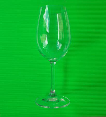 Glass for serving wine on a green background. High quality photoの写真素材