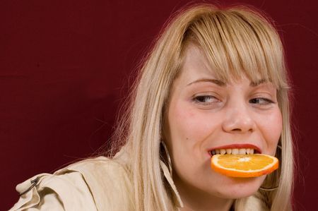 Young girl show and eating a piece of orangeの写真素材