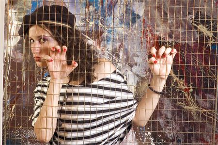 Young woman behid grid in fashion conceptの写真素材