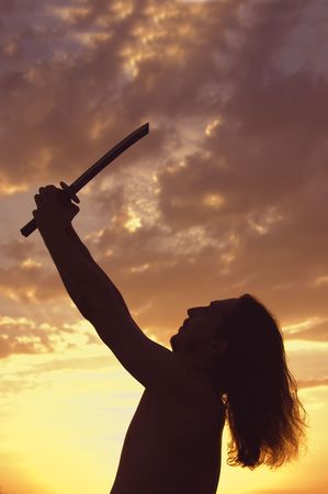 Man with sword in sunsetsの写真素材