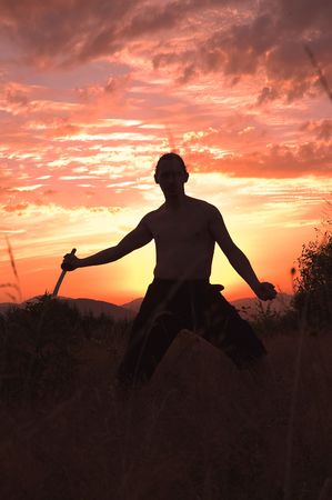 Man with sword in sunsetsの写真素材