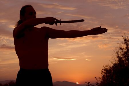Man with sword in sunsetsの写真素材