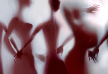 Silhouette of young woman, holding her hands behind linen textileの写真素材