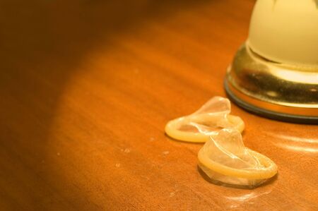 Condoms on the table in hotel's room beside night lampの写真素材