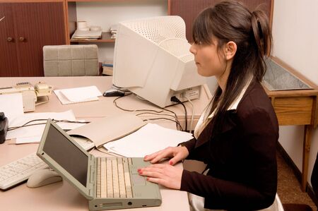 Young pretty business women in everyday job at officeの写真素材