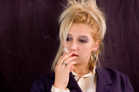 Young beauty blondie girl enjoyment with smoking cigaretteの写真素材
