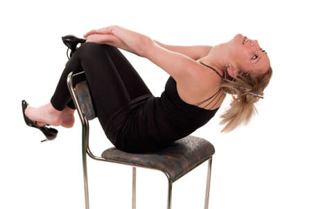 Beautiful young girl sitting on chair and holding shoesの写真素材