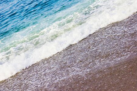 Waves crashing up to the sand beach