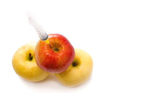 Three applies with syringe insertedの写真素材