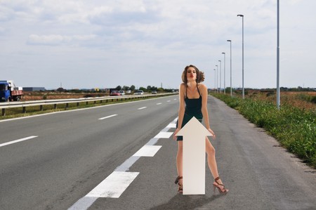 Adult woman hitchhike on highwayの写真素材