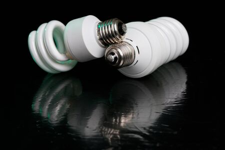Energy saving compact fluorescent lightbulb on black background with reflectionの写真素材