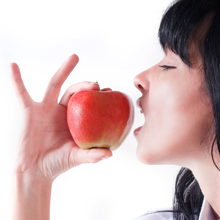 A young woman bite into an appleの写真素材