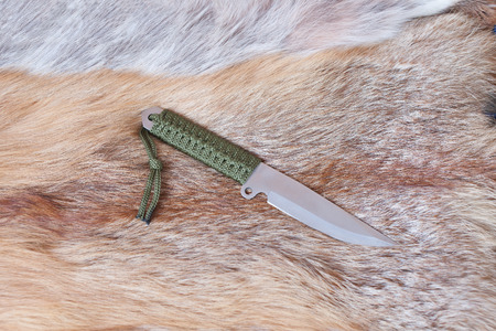 sharp hunting knife lies on the skin of a Foxの写真素材