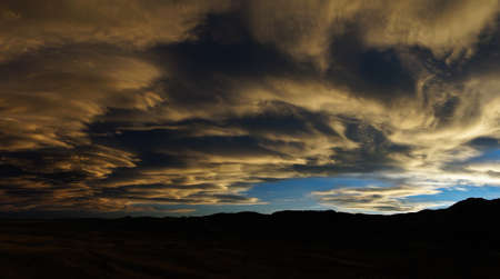 Swirling clouds at sunset over Colorado mountainsの写真素材
