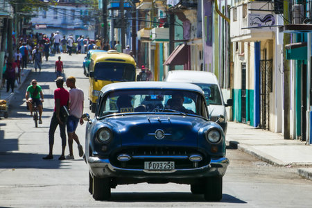 Lots of people street in Cuba with an old blue car. Havanaのeditorial素材