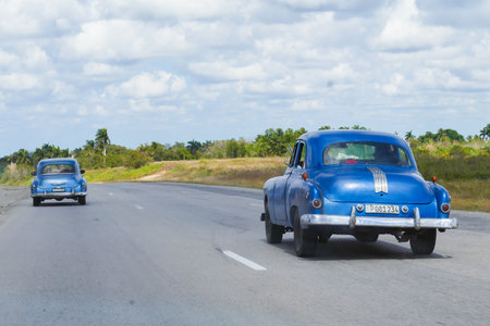 Cuba two old blue cars on the road. Photo taken from a carのeditorial素材