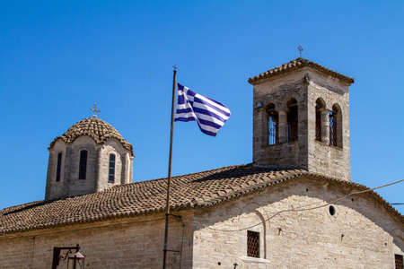 Afytos, Greece, July 9, 2021, Greek Flag on Agios Dimitrios Orthodox Churchの写真素材
