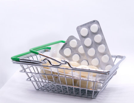 Pills and other medicines in a grocery basket on a light background. High quality photoの写真素材