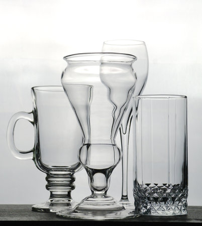 Transparent glass goblets and wine glasses on a light background, selective focusの写真素材
