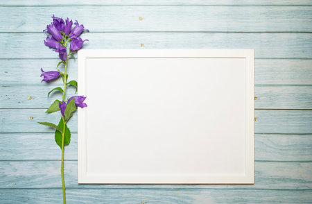 Horizontal white frame on a wooden turquoise background for mockup and flowers, copy space. High...