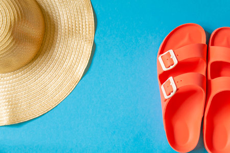 Beach accessories on blue background top view, copy space.