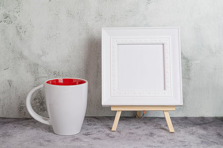 Minimalist interior with white mug and photo frame mockupの写真素材