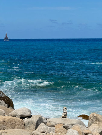 Mediterranean Sea in Calabria, Italy, sailing yacht and sea surf among rocks