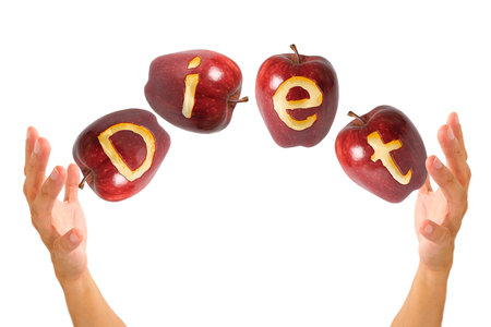 apple with text "diet" flying in the air between 2 handsの写真素材