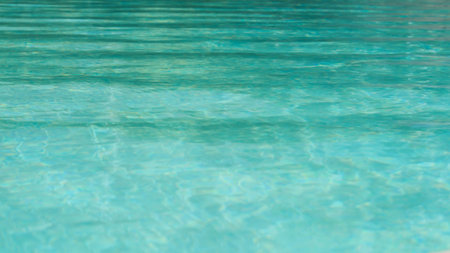 Blue pool water surface with sun reflectionsの写真素材