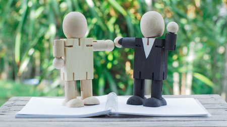 wooden doll of businessman have a deal on notebook, business conceptの写真素材