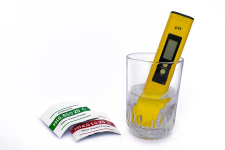 pH meter measuring the pH of the water in the glass on isolated white background. used solution solution packages.の写真素材