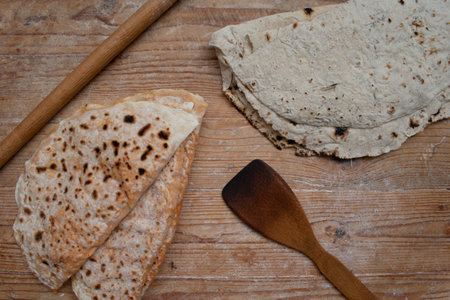 Traditional Turkish village pastry pancakes and village bread on wooden background. next to a wooden...