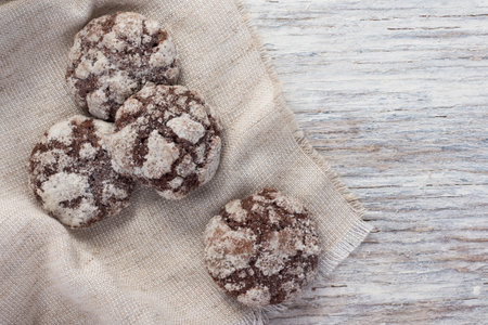 Chocolate cookies in a linen a napkin on a light wooden background