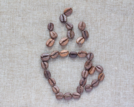 Cup of coffee beans on linen backgroundの写真素材